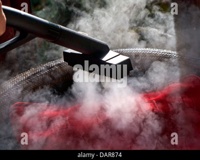 CORONAVIRUS STEAM CLEANING COVID-19 HOME FABRIC Domestic fabric anti viral bacteria steam cleaning in a sunlit conservatory interior Stock Photo