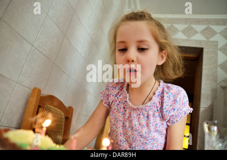 Girl blowing out candles at birthday party, Ukraine Stock Photo