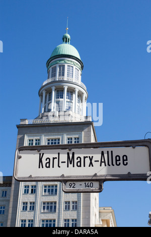 Karl Marx Allee sign with one of four Frankfurter Tor towers behind Friedrichshain Berlin Germany Stock Photo