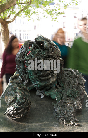 The bronze and granite sculpture “Conversation with Oscar Wilde” made by Maggi Hambling. People are rushing past to Charing Cross Station. London, UK. Stock Photo