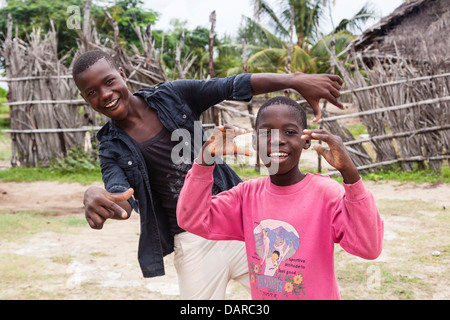 Africa, Mozambique, Quirimba Island. Teenage boys making signs for the camera. Stock Photo