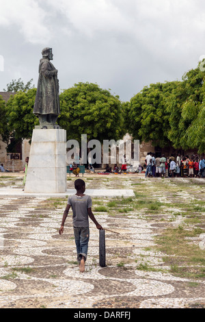 Africa, Mozambique, Mozambique Island. Young boy playing with a rubber tire in town square. Stock Photo