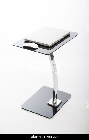Laptop computer and mouse standing on a glass table Stock Photo