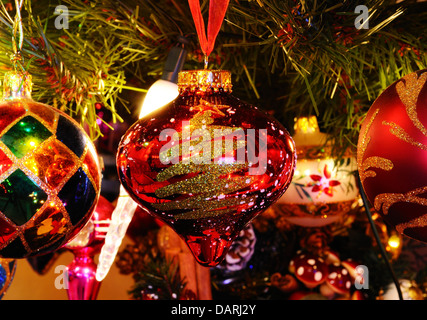 Red and gold glass Christmas globe hanging on a Christmas tree. Stock Photo