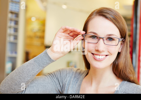 Attractive woman with new glasses in optician retail store Stock Photo