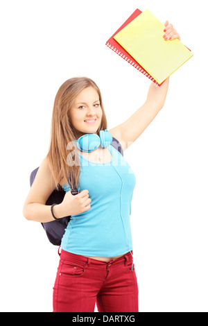 Young female holding books and gesturing thumbs up in front of camera ...