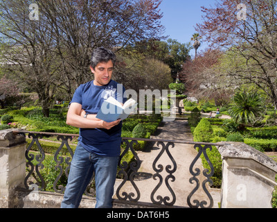 Man reading a book in park Stock Photo