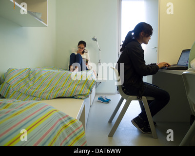 Two female students roommates studying in college dorm room Stock Photo
