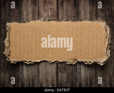 Torn cardboard on wood background Stock Photo