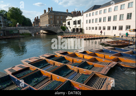A view across the mill pond in Cambridge towards the Anchor pub with lots of punts moored in the foreground on sunny summer day Stock Photo