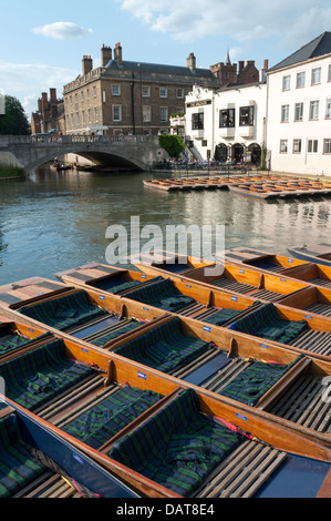 A view across the mill pond in Cambridge towards the Anchor pub with lots of punts moored in the foreground on sunny summer day Stock Photo