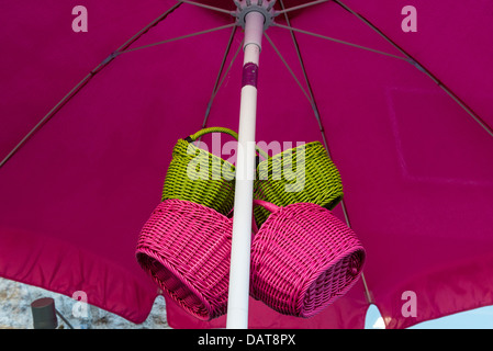 Pretty coloured baskets for sale under an umbrella at Saint-Bonnet-le-Froid, Haute-Loire department in south-central France. Stock Photo