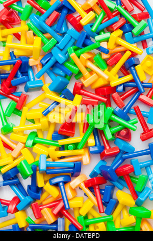 Many different toy puzzle mosaic pieces of different colors laying in a pile, red, yellow, green, blue Stock Photo