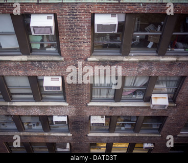 Air conditioners sprout from windows in an office building in New York Stock Photo