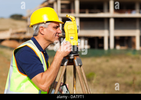 Senior land surveyor working with theodolite at construction site Stock Photo