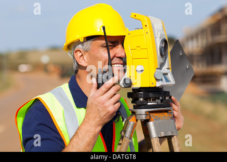 senior land surveyor working with tacheometer on construction site Stock Photo