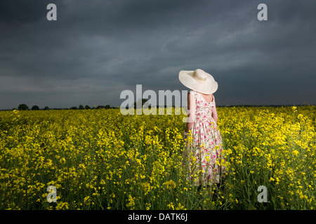 woman standing in field in open countryside with oilseed crop Stock Photo