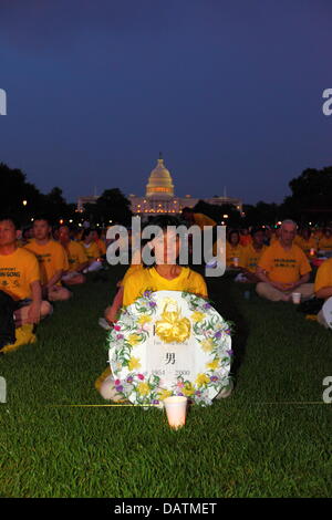 Washington DC, USA. 18th July, 2013. Falun Gong members commemorate the 14th anniversary of the Chinese government crackdown against them which began on 20th July 1999. Some people are holding tributes with the names of those who have been killed during the persecution. In the background is the United States Capitol Building. Credit:  James Brunker / Alamy Live News Stock Photo