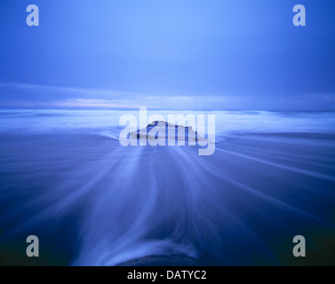 New Zealand. Landscape. North Island. Coast. Atmospheric blue close-up of tidal surge water swirling around rock. Stock Photo
