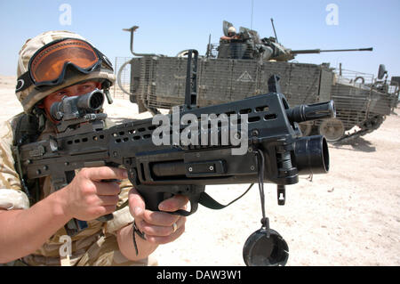 An infantryman of the British troops of the multinational 'Division South East' holds his assault rifle during a drill near Basrah, Iraq, June 2006. The soldier is part of the 'Princess of Wales' Royal regiment', in the back is a battle tank 'FV510 Warrior'. Photo: Carl Schulze Stock Photo
