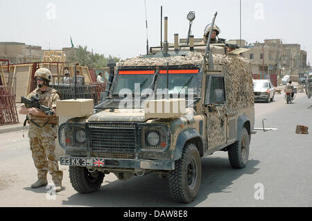 A British soldier of the Multinational Division South East is pictured with his SA80A2 assault rifle next to a Land Rover 110 Composite Armor Vehicle 'Snatch' during a patrol in Basra, Iraq, June 2006. Photo: Carl Schulze Stock Photo