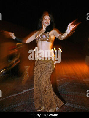 Belly dancer Criss Bonet dances for tourists during a dinner underneath bedouins' tents during a desert safari in the desert near Dubai, United Arab Emirates, 12 January 2007. Photo: Daniel Karmann Stock Photo