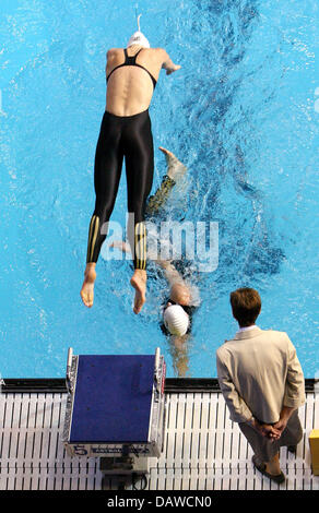 German swimmer Petra Dallmann (top) takes over from team mate Britta Steffen (bottom) at the women's 4x200 metres freestyle relay final at the FINA World Swimming Championships in Melbourne, Australia, Thursday, 29 March 2007. Germany finished Thursday second only to the US American team. Photo: Gero Breloer Stock Photo