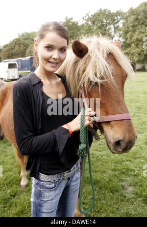 (dpa file) - German actress Christiane Klimt (R) smiles next to a horse during the 5th charity horse race at the racecourse in Cologne-Weidenpesch, Germany, 24 September 2006. Traditionally lots of celebrities came. Since 1954 the 'Kinderschutzbund Cologne' stands up for the improvement of childrens' and families' living conditions. Photo: Joerg Carstensen Stock Photo
