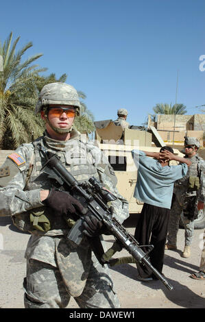 A soldier stands guard with his M4A1 carbine during a patrol in Bagdad ...