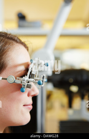 Young woman with trial frame for lens determination at optician