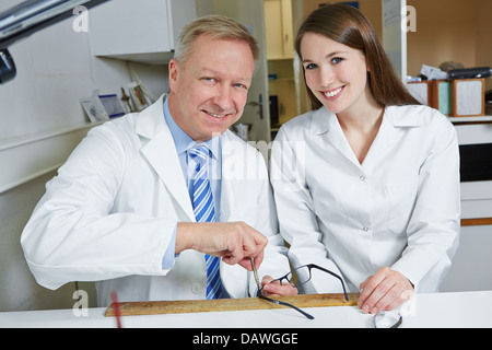 Optician and happy apprentice in workshop reparing glasses together Stock Photo