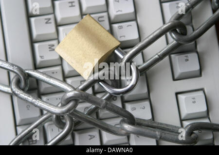 A steel chain connected by a padlock lies on top of a computer keyboard in Frankfurt Main, Germany, 19 May 2007. Photo: Tobias Felber Stock Photo