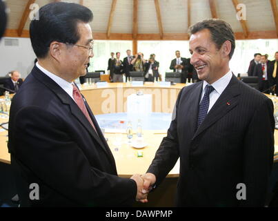 French President Nicolas Sarkozy (R) shakes hands with Chinese President Hu Jintao at a session with the so-called Outreach countries at the G8 Summit in Heiligendamm, Germany, 08 June 2007.  The G8 states declared their will to increase monetary aid for Africa. Photo: Michael Urban Stock Photo