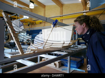 A visitor takes a look at a model of a Viking ship in the archeological workshop of the museum for Viking ships in Roskilde, Denmark, 22 May 2007. The model represents the most ambitious Viking ship project in the world. The long boat Skuldelev 2, a Viking warship with 30 metres length, is currently being reconstructed with tools from the Viking age. On 01 July 2007 it is going to 