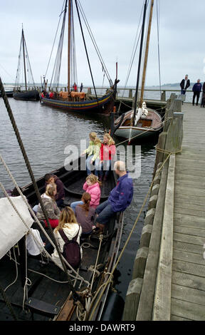 Visitors sit in one of several reconstructed Viking ships that lie in the harbour of the museum for Viking ships in Roskilde, Denmark, 22 May 2007. Shipbuilding and seafaring of the Vikings are presented in the museum that has its own wharf and an archaeological workshop and offers Viking ship boat trips in the summer. Photo: Maurizio Gambarini Stock Photo