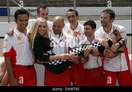 US-American model Bridget Lee poses with Ferrari mechanics at the race track in Indianapolis, USA, 14 June 2007. The USA Grand Prix will take place in Indianapolis on Sunday 17 June. Photo: GERO BRELOER Stock Photo