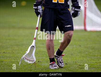 A Lacrosse player holds his crosse at the German Championships in Munich, Germany, 16 June 2007. Lacrosse is a team sport that is played with ten players (men's field), or twelve players (women's field), each of whom uses a netted stick (the crosse) in order to pass and catch a hard rubber ball with the aim of scoring goals. Lacrosse is the second national sport after Ice Hockey in Stock Photo