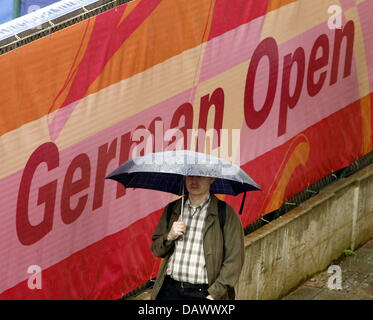 A fan is pictured under an umbrella while waiting for the Qatar Telecom German Open to begin at the Steffi Graf Stadium in Berlin, 07 May 2007. Photo: Wolfgang Kumm Stock Photo