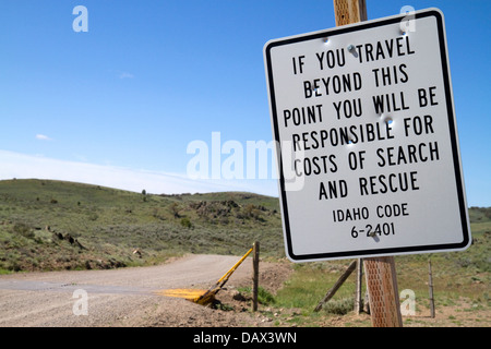 Road sign warning of search and rescue costs for traveling on unimproved road in Owyhee County, Idaho, USA. Stock Photo