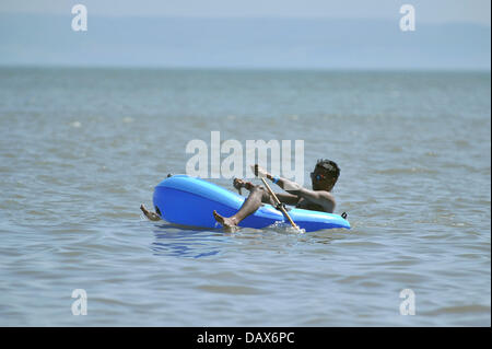 BARRY ISLAND, UK. 19th July 2013. The British heatwave continues and people flock to the beaches in South Wales. A man relaxes in a dinghy in the sea. Photo credit Credit:  Polly Thomas / Alamy Live News Stock Photo