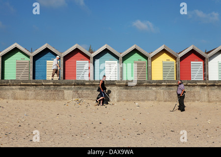 Men by colourful beach huts at Blyth in Northumberland, England. Stock Photo