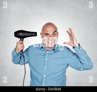 Bald guy holding hair dryer in his hand Stock Photo