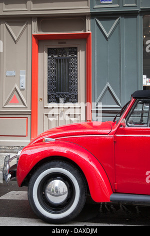 A red Volkswagen Beetle parked in the courtyard of a traditional ...