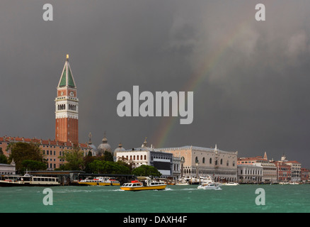 After a huge storm, the colorful rainbow spreads over St. Mark's Square in Venice, Italy illuminates the landscape. Stock Photo