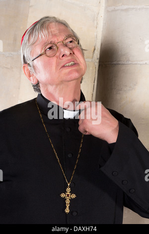 Mature cardinal annoyed by the pinching priest collar in his shirt or cassock Stock Photo