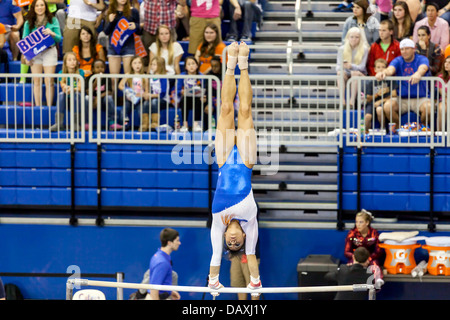 Woman competes on uneven parallel bars during Alabama Crimson Tide versus UF Gators Women's Gymnastics Meet (2-8-13). Stock Photo