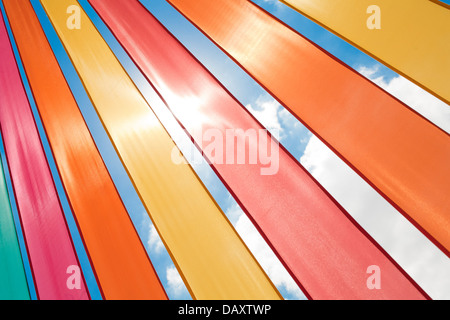 Multi-coloured ribbons lit by bright sunlight against a summer sky. Stock Photo