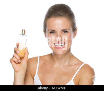 Smiling young woman showing perfume bottle Stock Photo