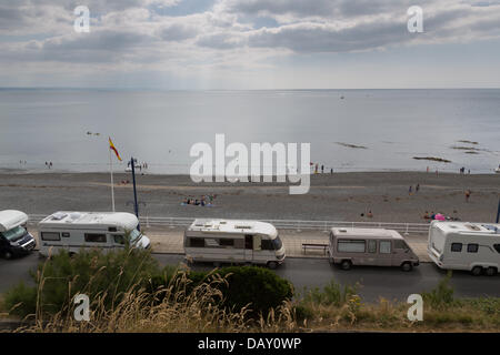 Aberystwyth, Wales, UK, 20 July 2013,  Camper van owners who park along Aberystwyth promenade make the most of the heatwave and lack of parking restrictions. On Saturday, 23 camper vans were counted parked along the promenade. Some local residents have complained that having vans constantly parked day and night on the prime seafront, with 'residents' extending and spilling out their living areas onto the pavement, is detrimental to the town. Credit:  atgof.co/Alamy Live News Stock Photo