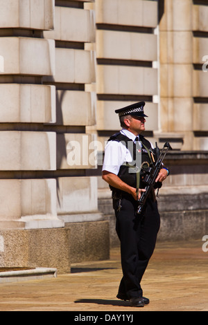 Royal protection police officer patrolling in front of Buckingham palace, London Stock Photo